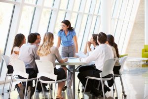 a team gathers around a table