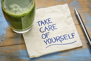 a napkin with juice on a table that says "take care of yourself"