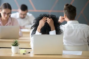 frustrated office worker with head in her hands